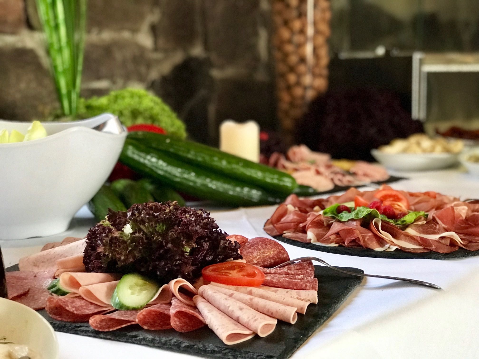Eine Auswahl an Speisen, darunter Fleisch, Gemüse und Salate, auf einem Tisch angerichtet.