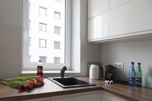 Apartamento executivo, 2 quartos, cozinha americana | Cozinha americana privada | Geladeira, fogão, cooktop, lava-louças