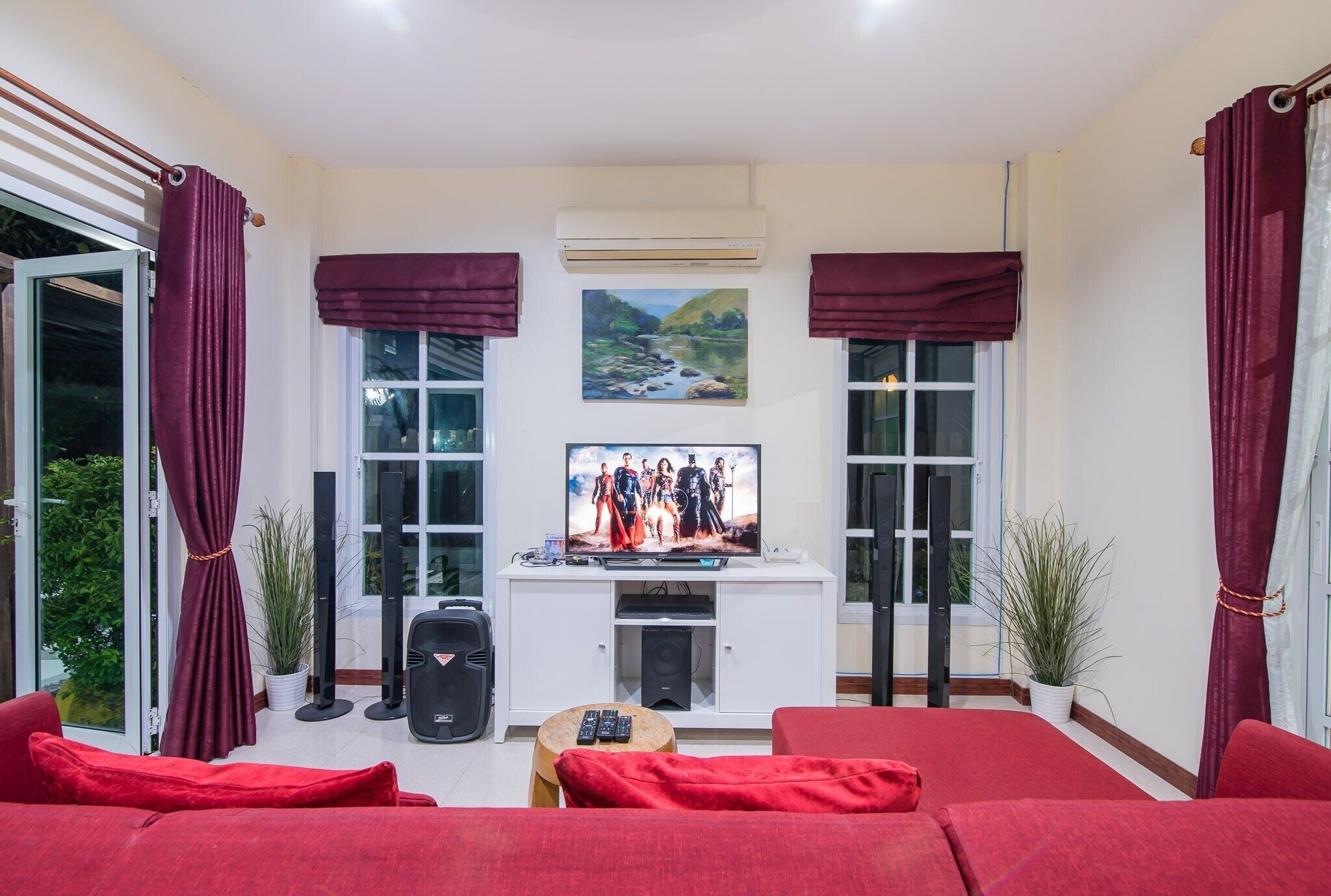 A living room with red sofas, a TV, and a white entertainment unit.