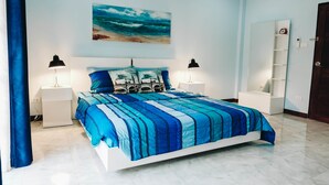 Una camera da letto con un letto, due comodini, una mensola a parete e una porta.