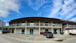 Un immeuble à plusieurs étages doté de balcons, d’un espace d’accueil et d’un parking.