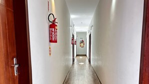 Un long couloir étroit, doté d’un plancher en bois et de murs blancs.