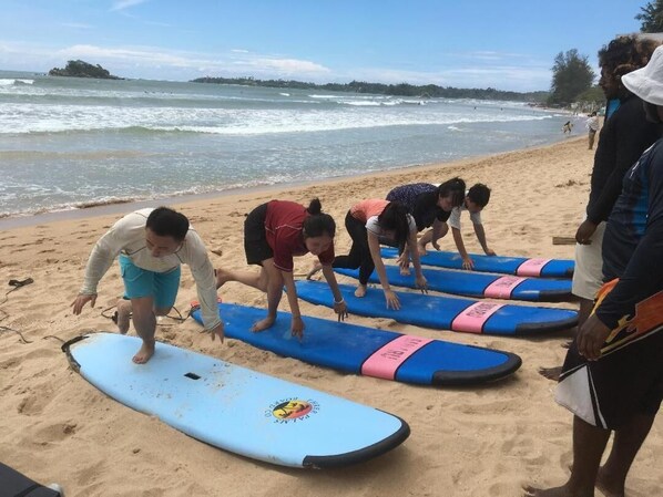 A group of people on a beach with surfboards.