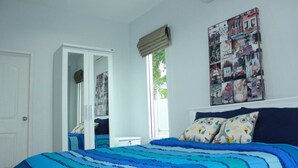 A bedroom with a bed, a window with a view, a door, and a wall with a collage of images. - Pitchayapa Hua Hin Pool Villa Holiday (Hua Hin)