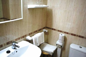 A bathroom with a sink, toilet, and a mirror. - Hostal Mary (Lloret de Mar)