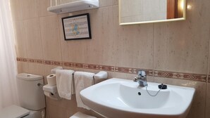 A bathroom with a toilet, sink, and towel rack. - Hostal Mary (Lloret de Mar)