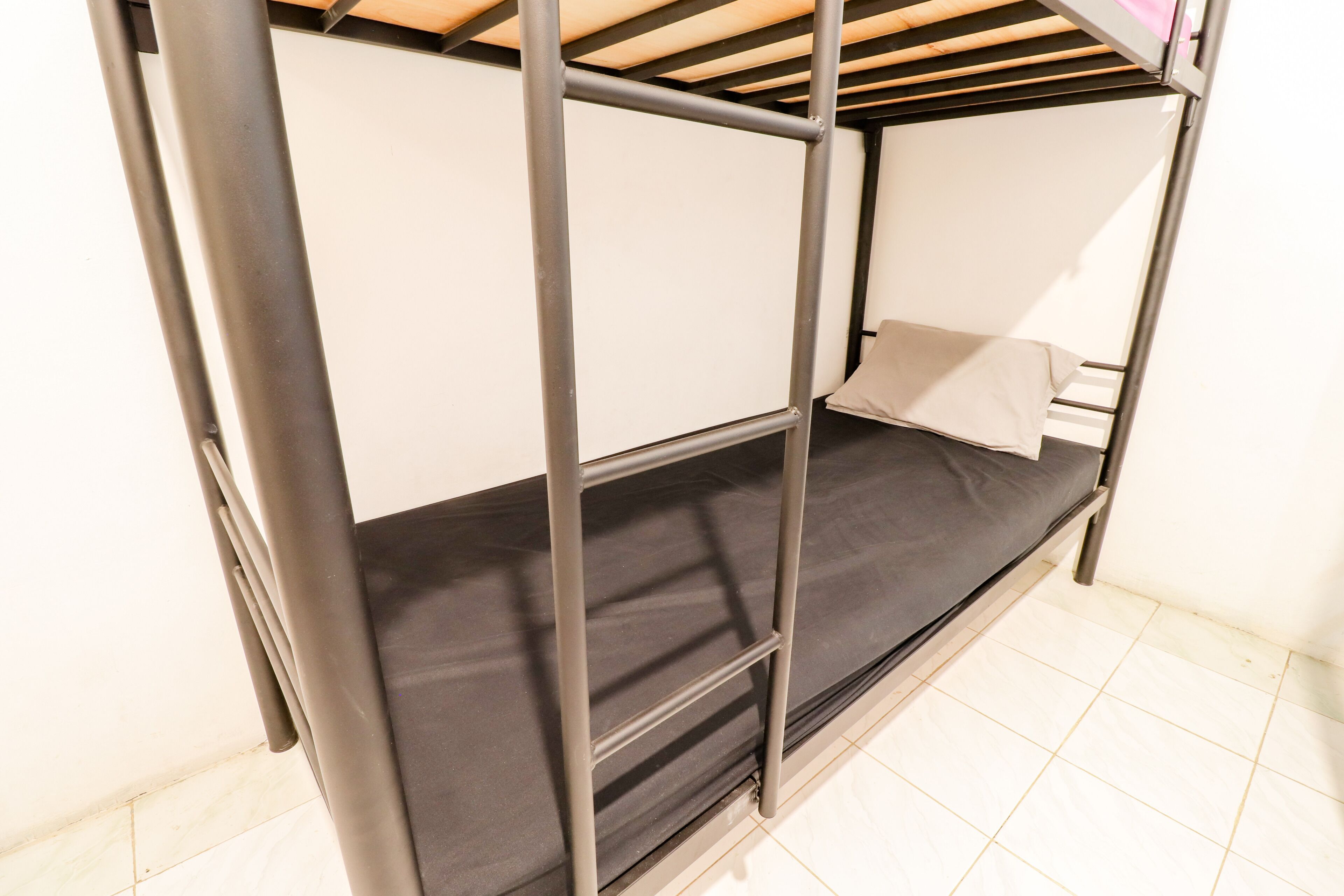 Una cama litera con barandillas de metal y un colchón.