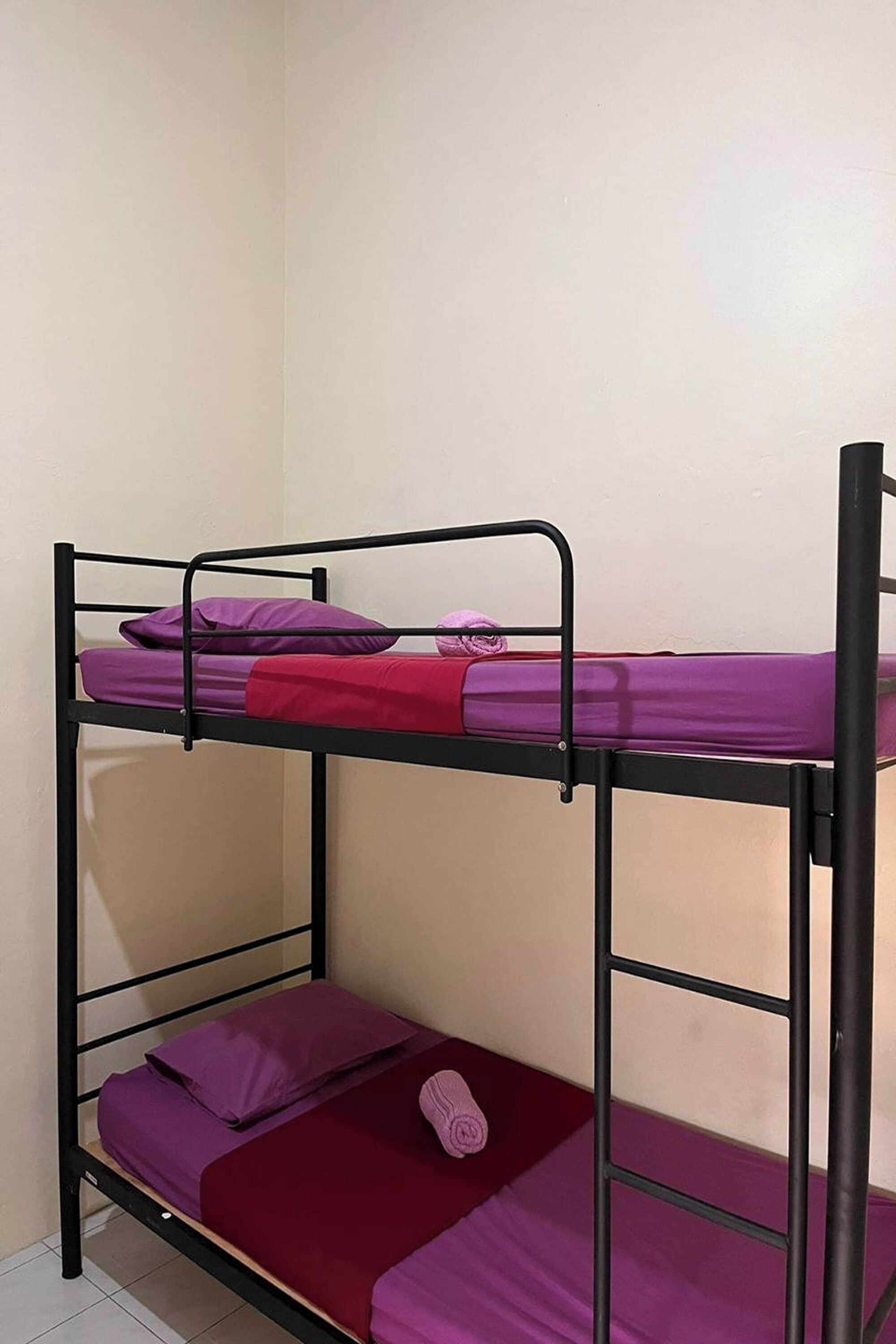 A bunk bed with two levels, each with a mattress and pillows.