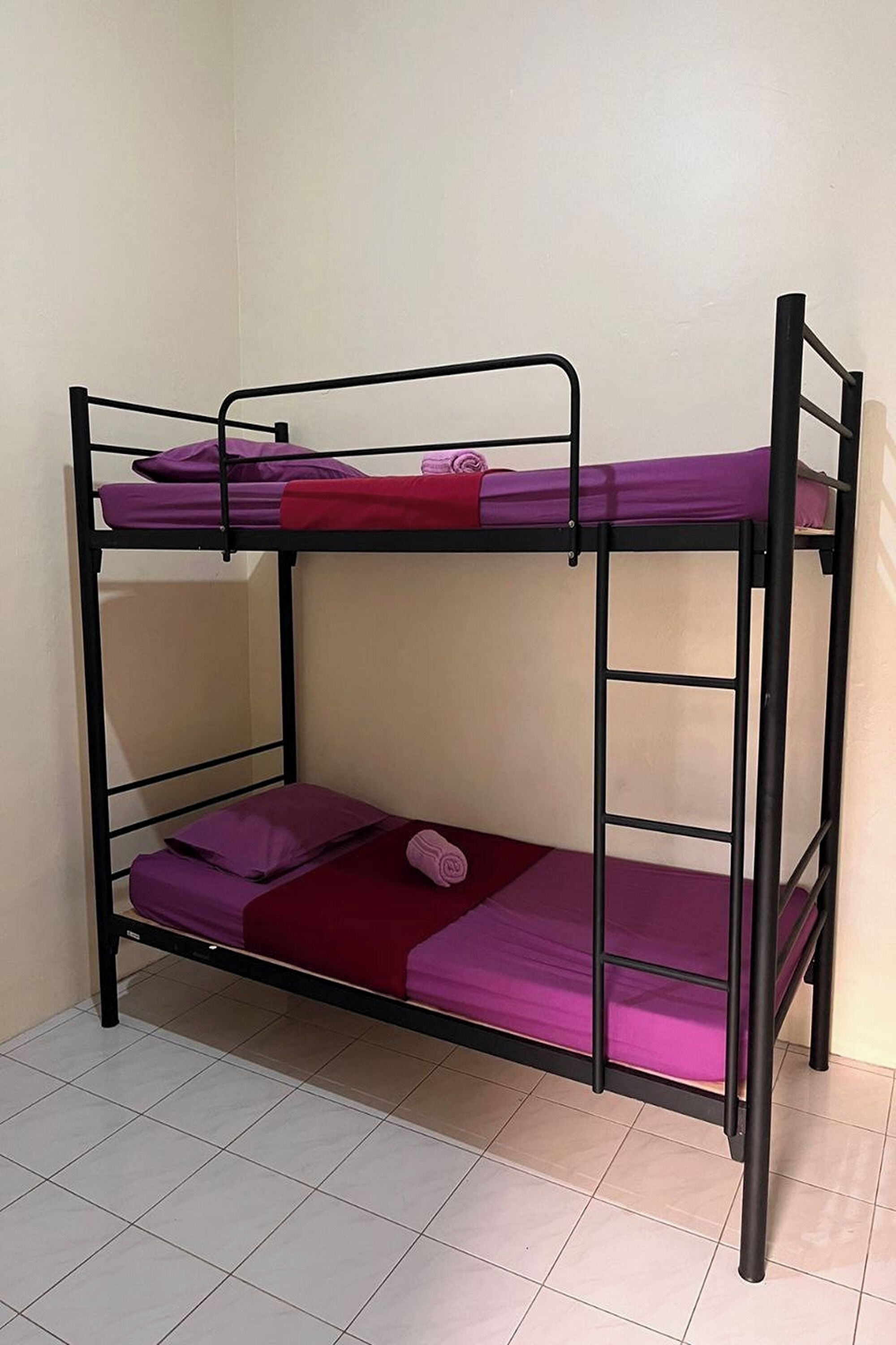 A bunk bed with two levels, each with a mattress and pillows.