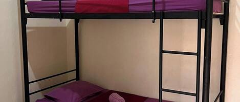 A bunk bed with two levels, each with a mattress and pillows.