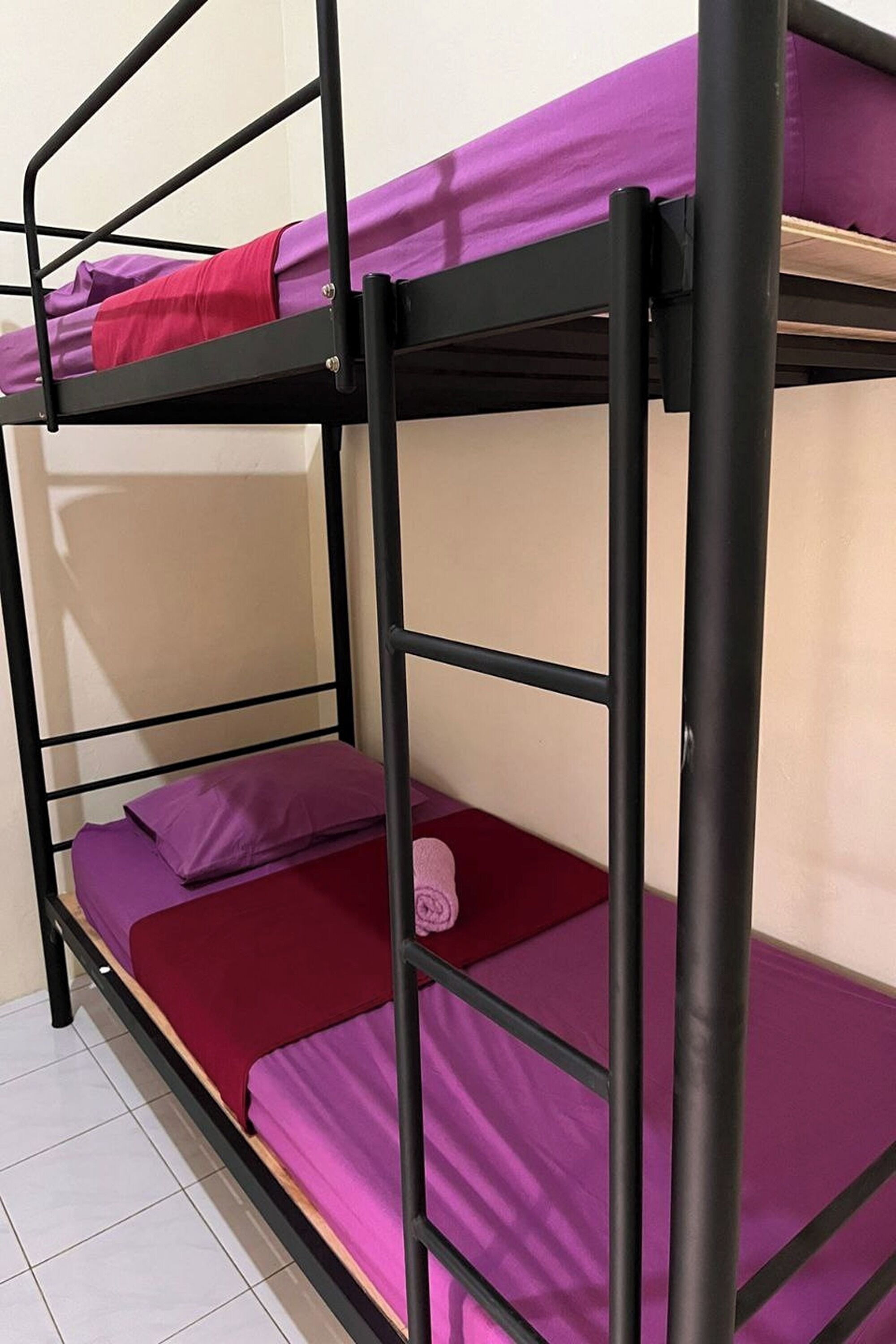 A bunk bed with two levels, each with a mattress and pillows.
