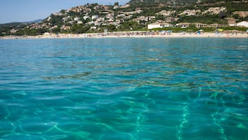 Plage, sable blanc, chaises longues, parasols