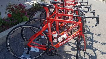Una hilera de bicicletas rojas Pinarello estacionadas en una calle.