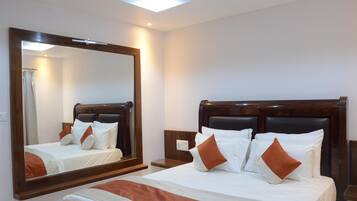 Een hotelkamer met een groot bed, een houten hoofdeinde, een nachtkastje en een grote spiegel.