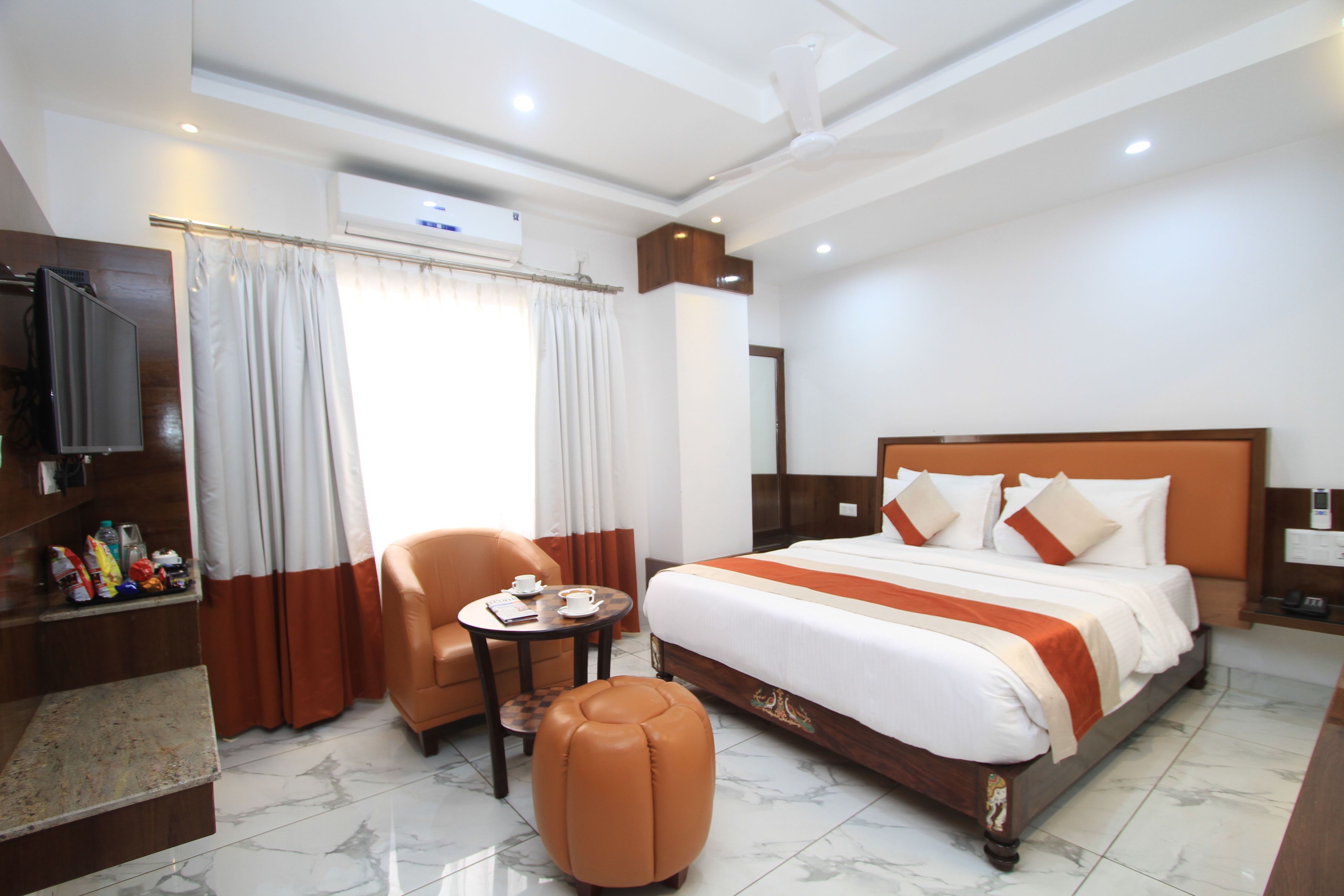 Une chambre d’hôtel avec un lit, une télévision, un bureau et une chaise.