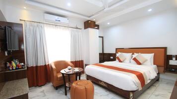 Une chambre d’hôtel avec un lit, une télévision, un bureau et une chaise.