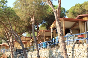 A coastal hotel with multiple rooms, outdoor seating, and a stone wall.