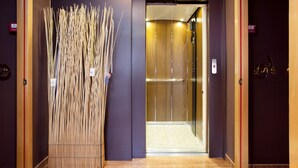 Un ascenseur avec un intérieur en bois et une porte en verre.