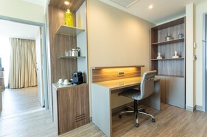 Un espacio de oficina moderno con un escritorio, una silla y estanterías con utensilios de cocina.