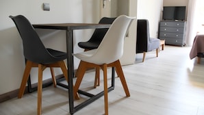 A dining area with a table and chairs, a television, and a dresser. - Résidence les Caraibes (Sérignan)