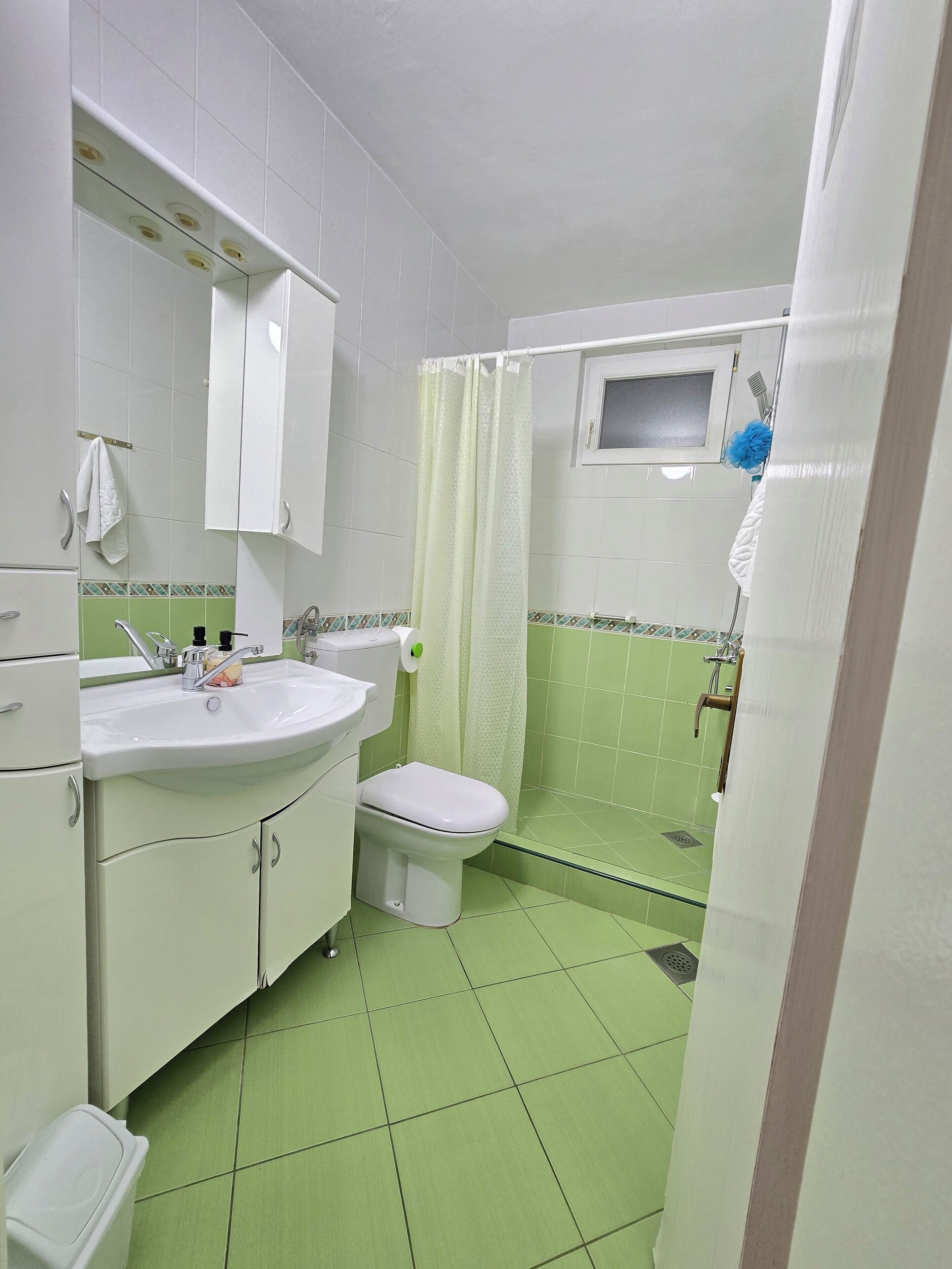 Ein Badezimmer mit Toilette, Waschbecken und Duschbereich.