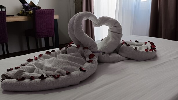 A hotel room with a bed, a desk, and a mirror.