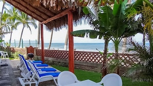 Patio vista mare con poltrone e tavolo.