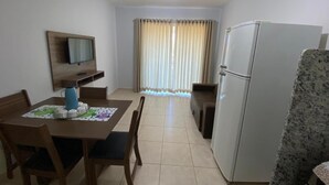 A compact living space with a dining area, a kitchenette, and a small seating area. - Thermas do Bosque Lineacaldas (Caldas Novas)