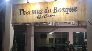 The exterior of Thermas do Bosque hotel with a signboard, entrance, and potted plants. - Thermas do Bosque Lineacaldas (Caldas Novas)