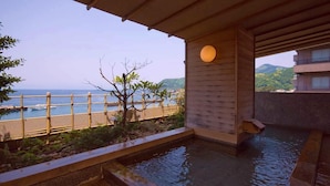 A wooden deck with a view of the sea, a small tree, and a water feature. - Aoki-nagi-no-yado Meijikan (Izu)