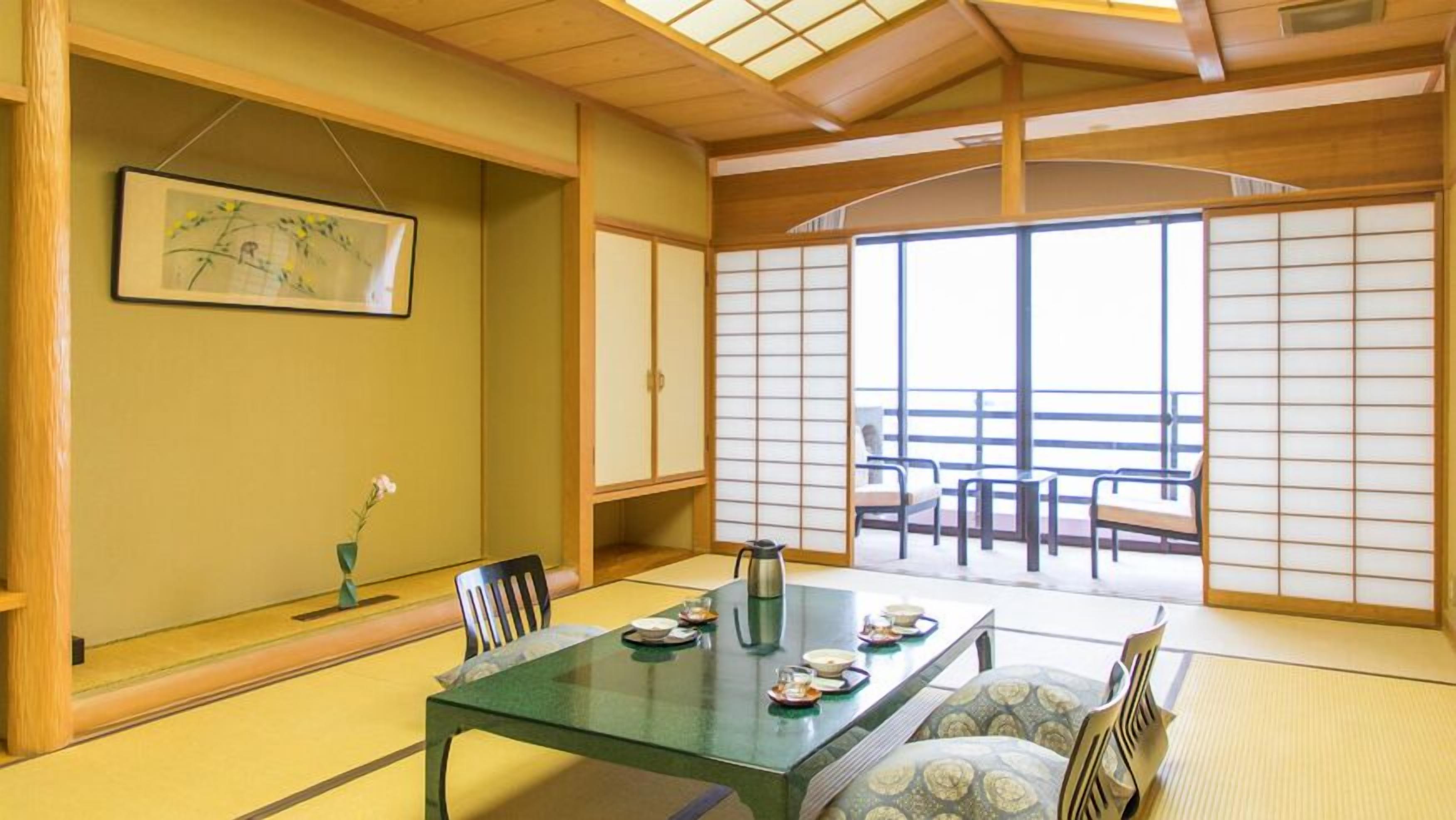 Ein traditioneller japanischer Raum mit Tatami-Böden, einem niedrigen Tisch mit Tee-Set und Schiebetüren.