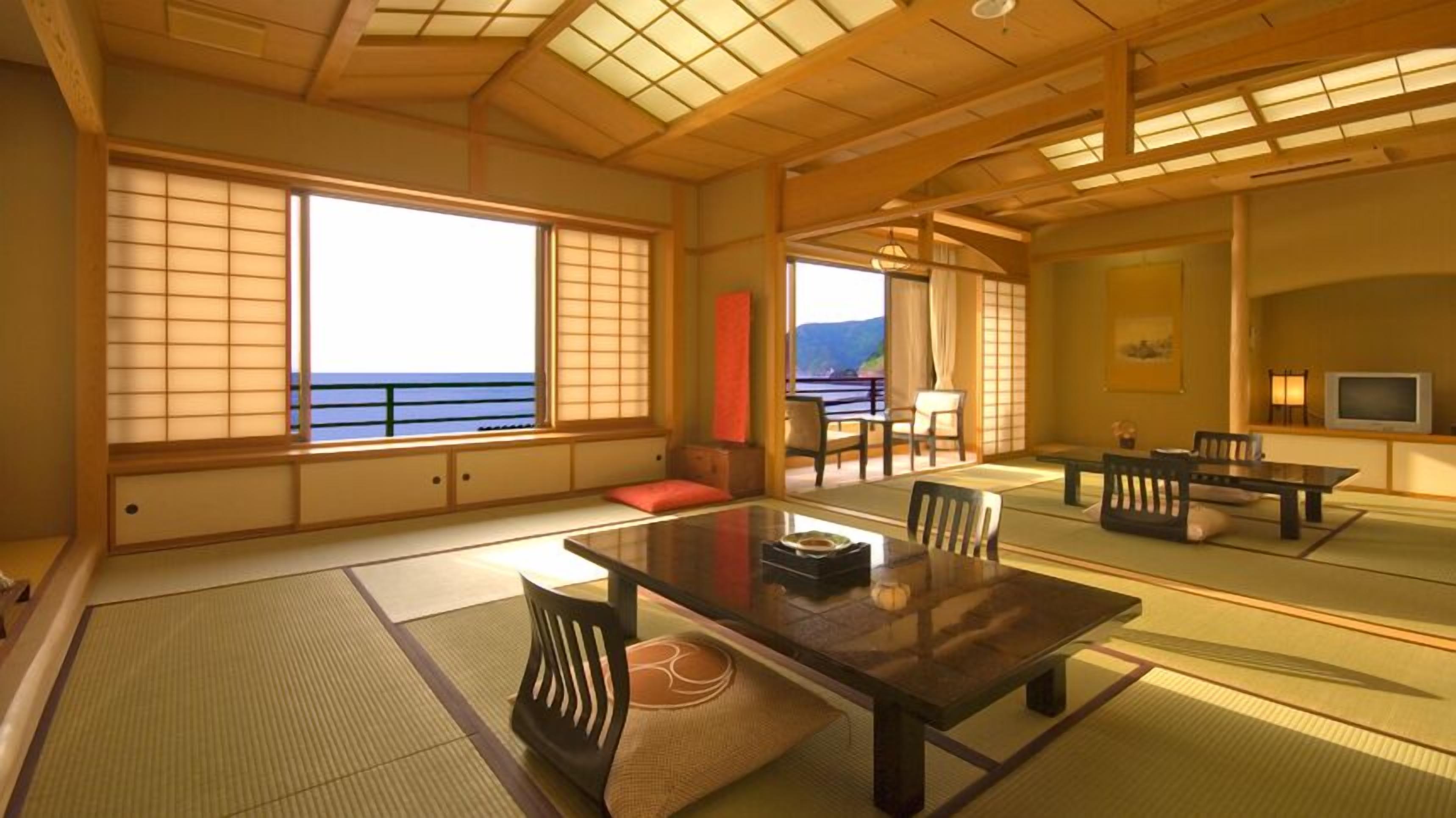 Ein traditioneller japanischer Raum mit Tatami-Bodenbelag, einem niedrigen Tisch und Schiebetüren.