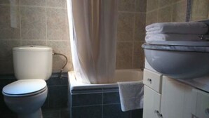 A bathroom with a toilet, a sink, and a bathtub. - Hotel Luz de Guadiana (Ayamonte)