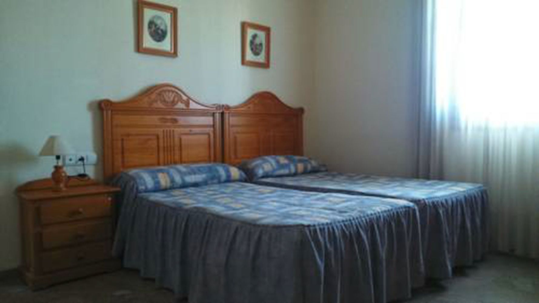 Un dormitorio con una cama de madera, dos mesitas de noche y una lámpara.
