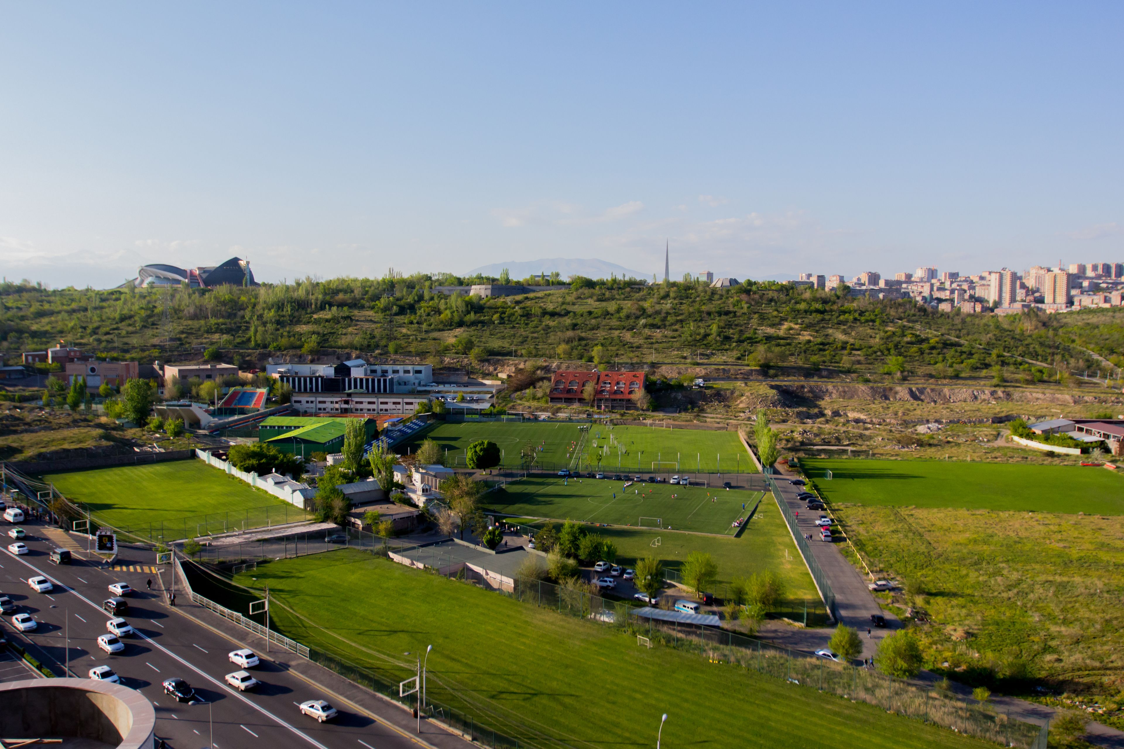 A stadium with multiple sports fields and parking areas.