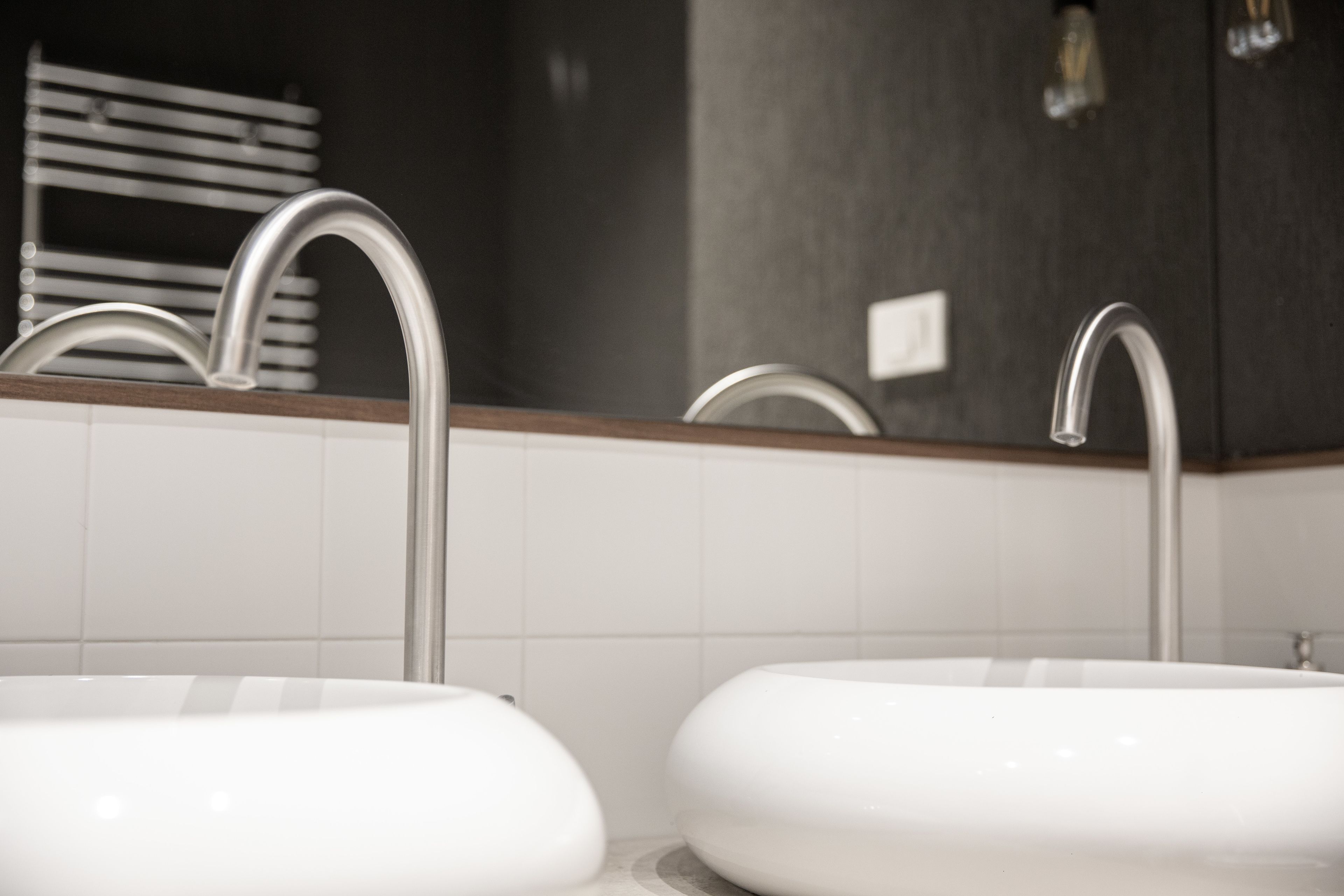 A bathroom with two sinks, a towel rack, and a mirror.