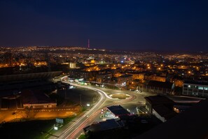 A nighttime cityscape with a roundabout and illuminated buildings.