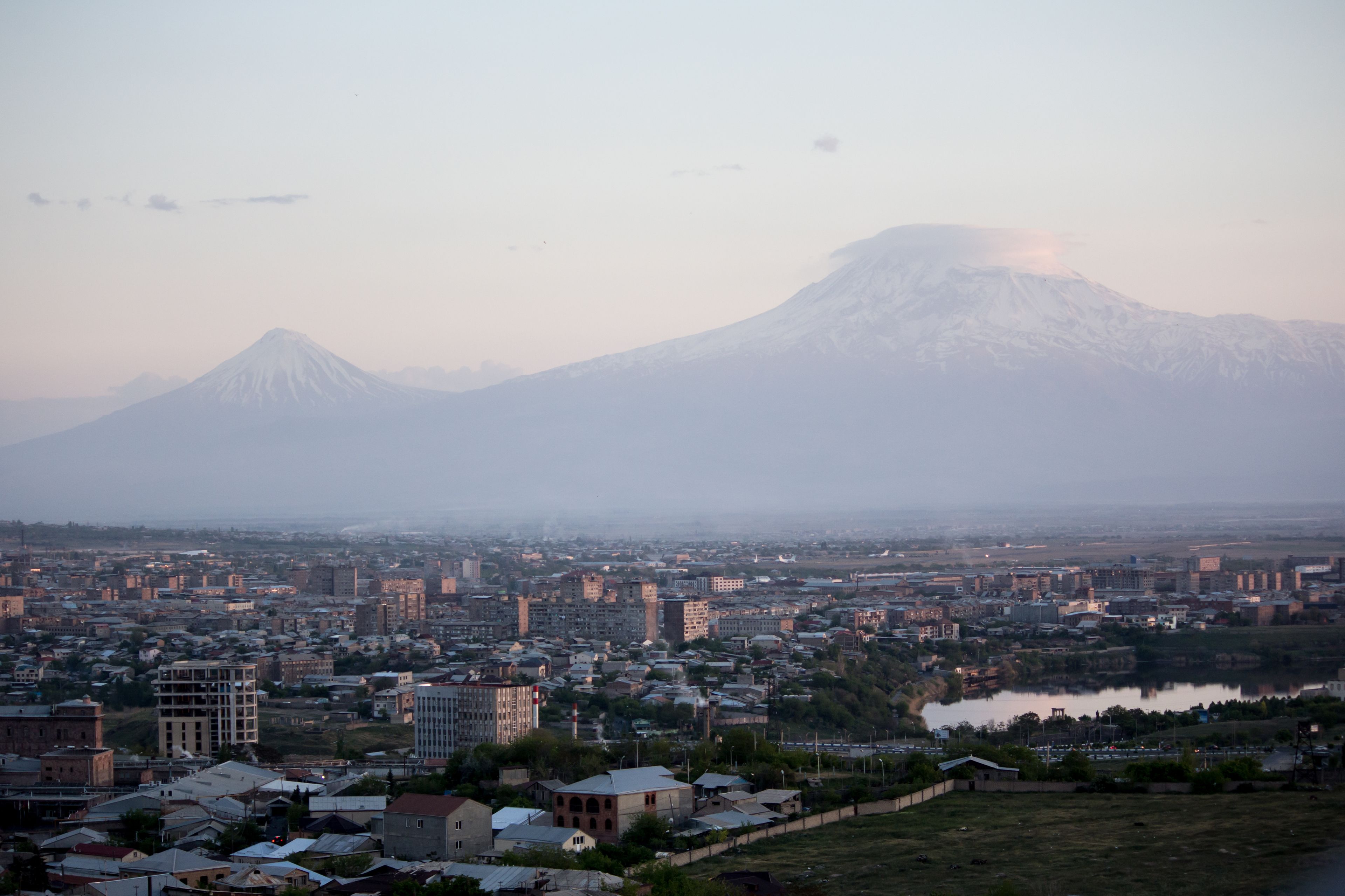 A cityscape with a prominent mountain in the background.