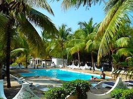 A pool area with lounge chairs and palm trees.