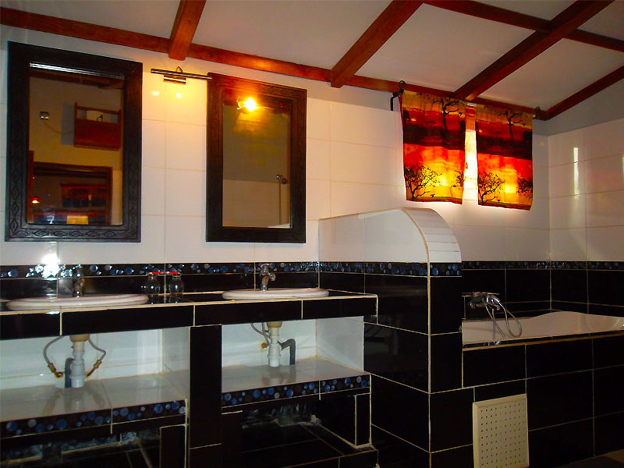 A bathroom with two sinks, a mirror, and a towel rack.