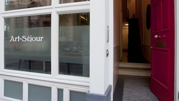 Un edificio con escaparate que muestra un ventanal con el texto "Art Séjour".