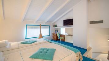 A modern hotel room with a large bed, a desk, and a television.