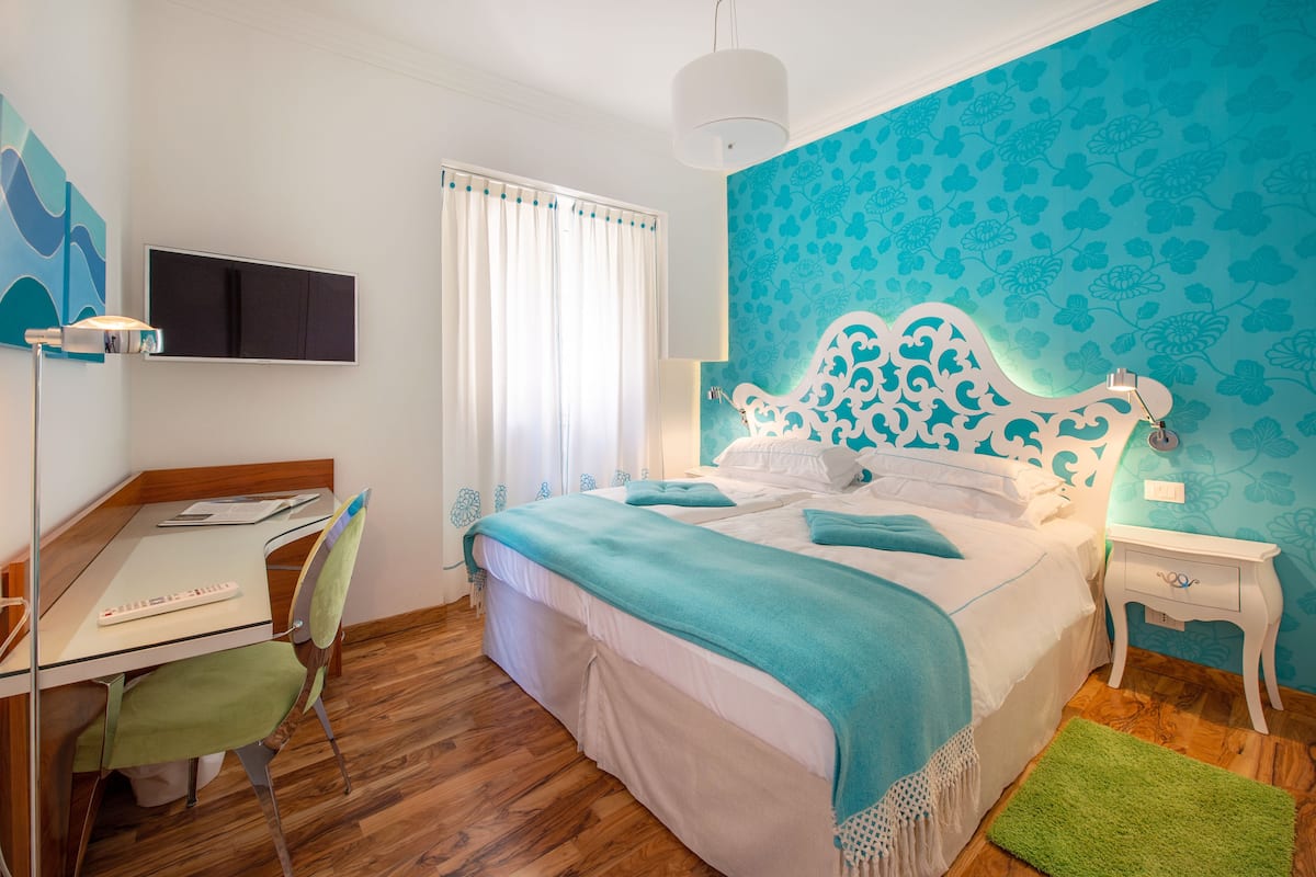 A bedroom with a bed, a desk, and a chair.