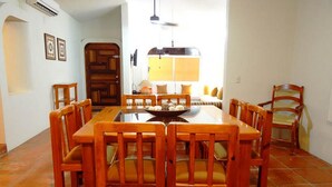 A dining area with a wooden table and chairs, a sofa, and a lamp.