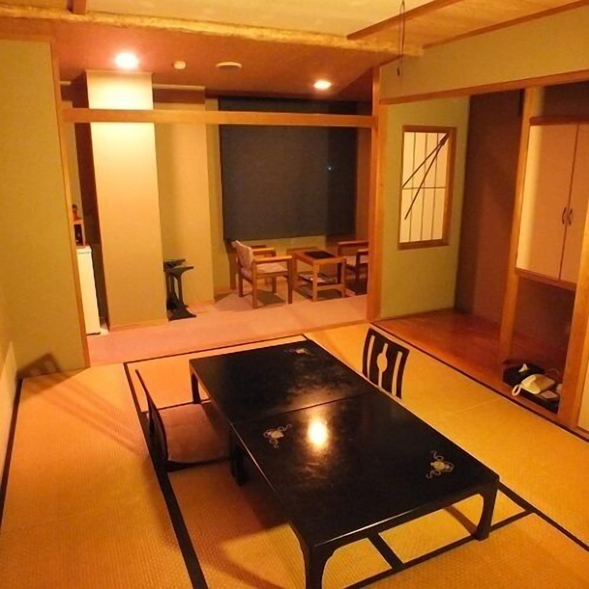 A traditional Japanese-style room with tatami flooring, a low table, and sliding doors.