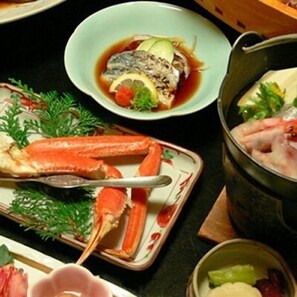 A dining table with seafood dishes, including crab legs and a bowl of soup.
