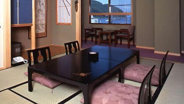 A dining area with a table, chairs, and a view of the sea.