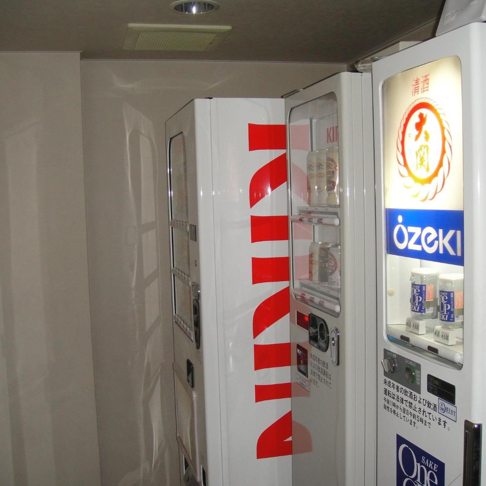 A vending machine with a prominent red logo, a beverage dispenser, and a sign with Japanese text.