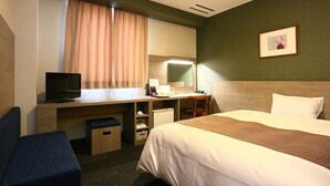 A hotel room with a bed, a desk with a computer, a television, and a small seating area. - Hotel NEW Shizuoka (Shizuoka)