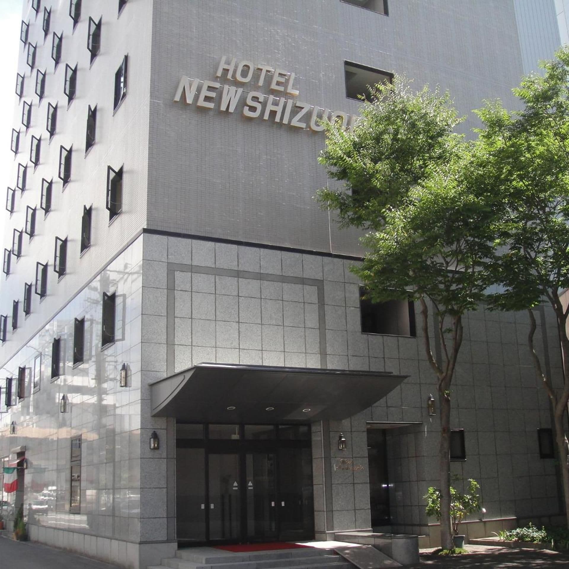 A hotel entrance with a sign reading 'HOTEL NEW SHIZUOKU'.